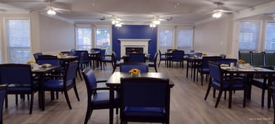 Dining room with tables set for meals and decor featuring sunflowers.