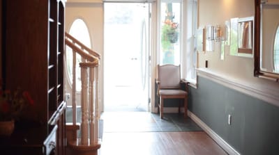 A well-lit hallway with a chair and open door