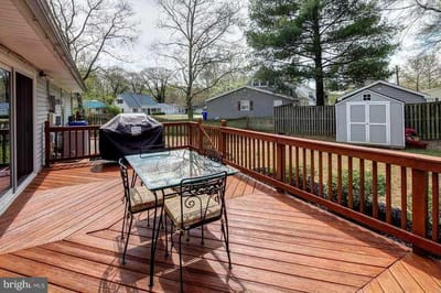 Deck area with a table and grill in the backyard