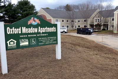 Exterior view of Oxford Meadow Apartments with sign