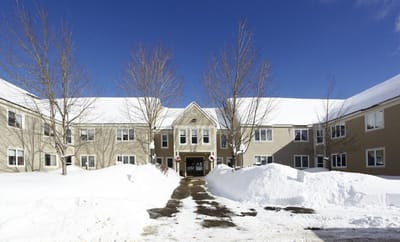 Exterior view of the Oxford Meadow Apartments covered in snow