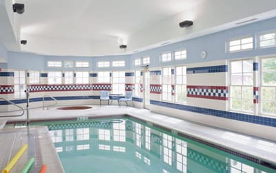 Indoor pool area with large windows and seating