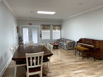 Bright common area with seating and piano