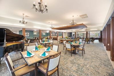 Dining room with elegantly set tables and piano
