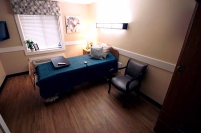 A private resident room with a bed and seating area