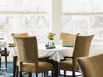 Dining area with tables and chairs by the windows