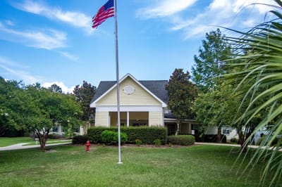 Building exterior of River Chase Village with American flag