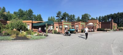 Exterior view of Russell Park Rehabilitation & Living Center with residents and staff
