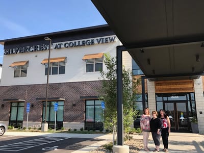 Staff members at the entrance of Silvercrest at College View