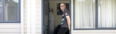 Resident at the entrance of their unit smiling