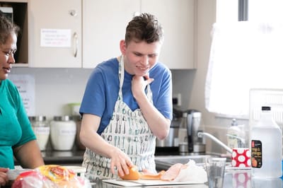 Resident participating in a cooking activity in the kitchen
