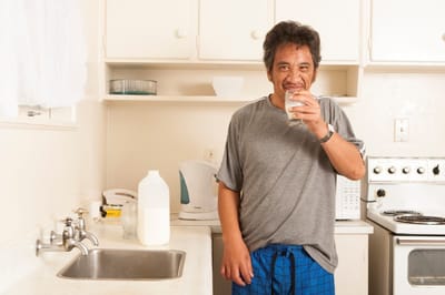 Resident drinking a glass of water in the kitchen