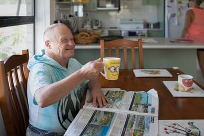 Resident enjoying coffee while reading a newspaper