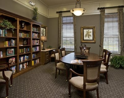 A cozy common area with bookshelves and a large table
