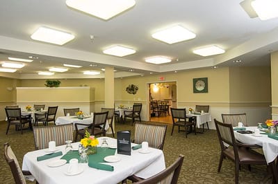 Dining room with neatly set tables and flowers