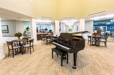 Interior view of a common area with a piano and tables