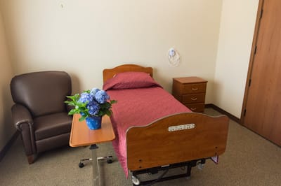 A resident room with a single bed and a chair