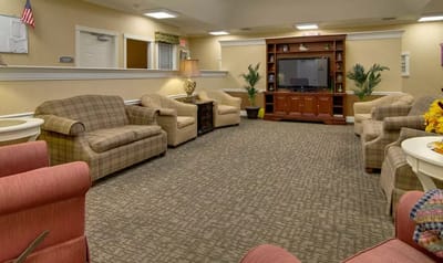 Common area with seating and television in a senior living facility
