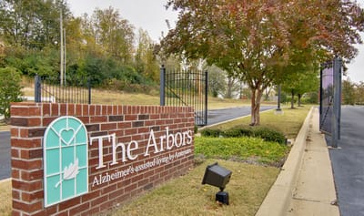 Exterior sign of The Arbors senior living facility