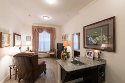 Cozy resident room with a recliner and lamp