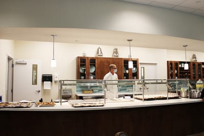 Staff member serving food in the dining area