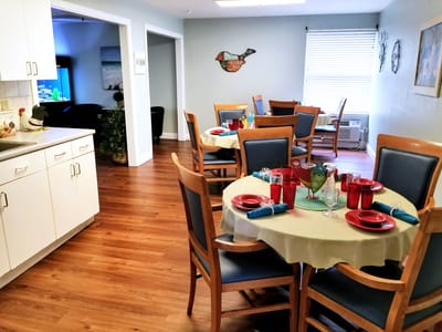 Dining area set for a meal with red glasses and plates