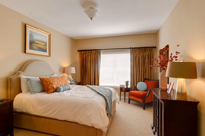 Cozy interior of a private resident room with decorated bed and seating area