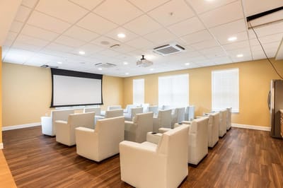 Bright, modern common area with seating and a projector