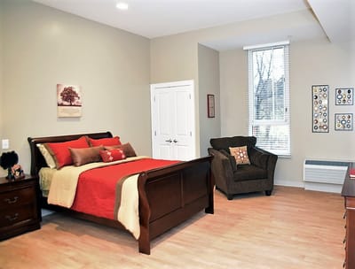 Brightly lit private resident room with wooden furniture