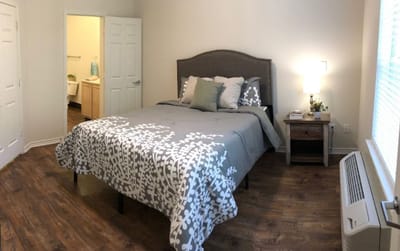 Bright private resident room with a bed and lamp
