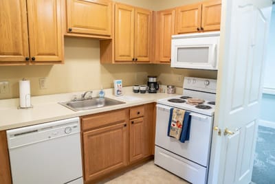Bright kitchenette with wooden cabinets and appliances