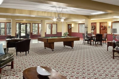 Bright activity room with a pool table and seating