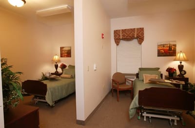 A cozy resident room with two beds and lamps