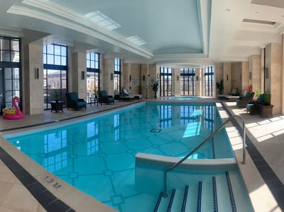 Indoor swimming pool area with seating and plants