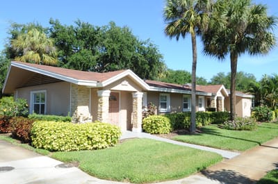 Exterior view of a single-story building with palm trees