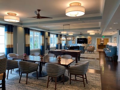Common area with seating and pool table in a senior living facility