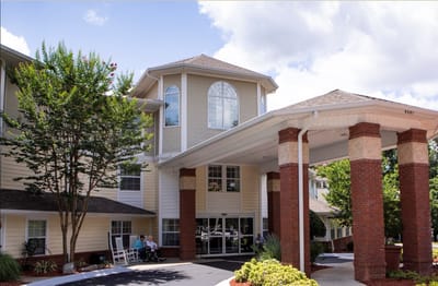 Entrance of a senior living facility with outdoor seating