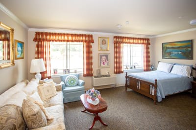 Cozy interior of a resident room with a bed and seating area