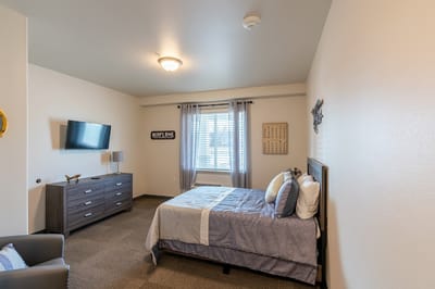 A private resident room with a bed and TV