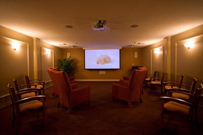A cozy interior theater room with chairs and a projector screen