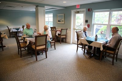 Residents enjoying a meal in a dining room setting