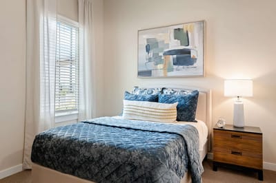 Cozy interior of a resident's room with a bed and artwork