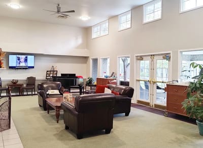 Common area with seating and piano in a senior living facility