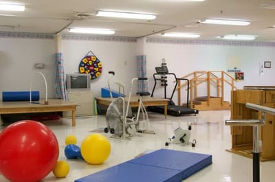 Rehabilitation exercise room with various equipment and balls