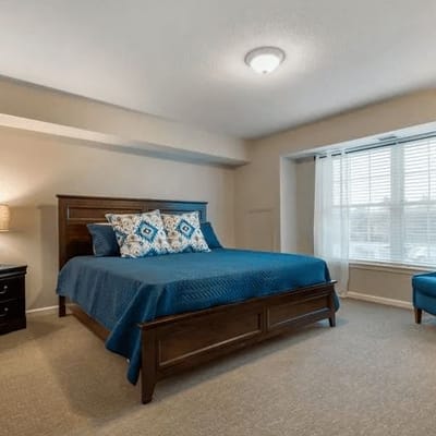 A well-furnished resident bedroom with a bed and window