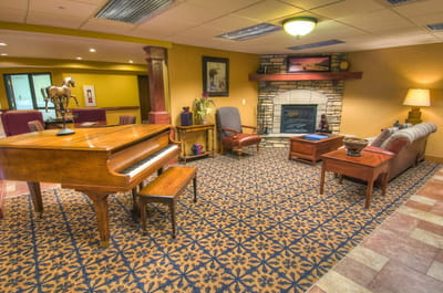Common area with a piano, seating, and fireplace