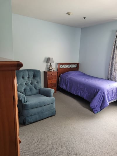 Cozy private resident room with bed and chair