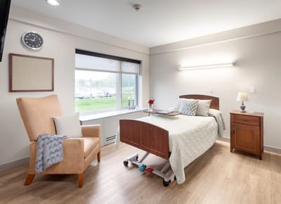 Cozy resident room with a bed and armchair