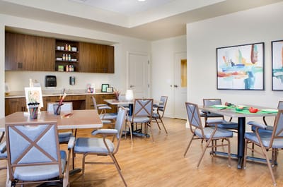 Bright common area with dining tables and art