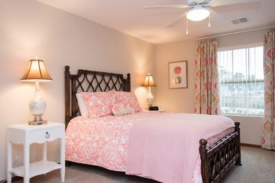 A cozy bedroom setup with floral bedding and lamps